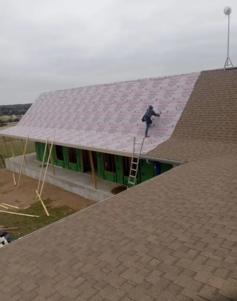 Worker preparing underlayment for a metal roof installation in Kahaluu-Keauhou